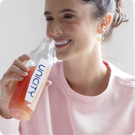 Žena pije pripremljeni napitak iz Unicity boce